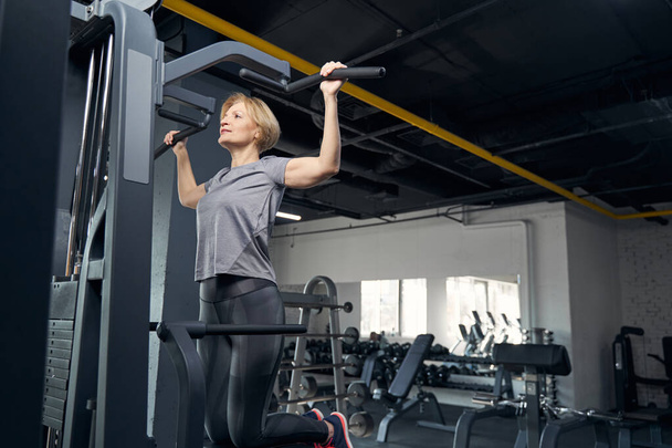 Woman in sportswear having workout with gym equipment - Fotoğraf, Görsel