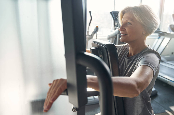 Cheerful sporty woman having workout in gym - Foto, Bild