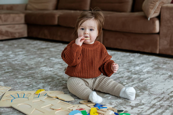Aranyos baba játszik színes szivárvány játék. Egy fejlődő színű fa játék betűk és számok. - Fotó, kép