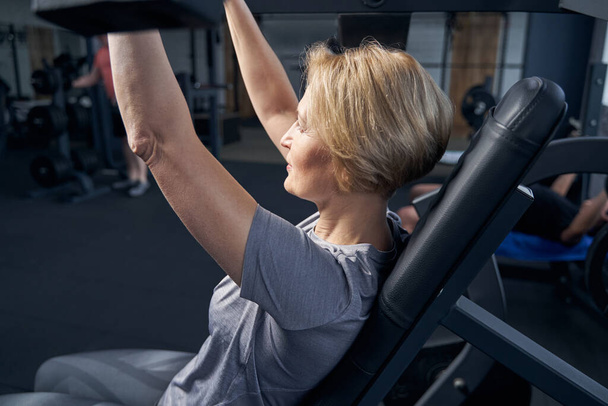 Blonde woman having workout in fitness club - Fotoğraf, Görsel