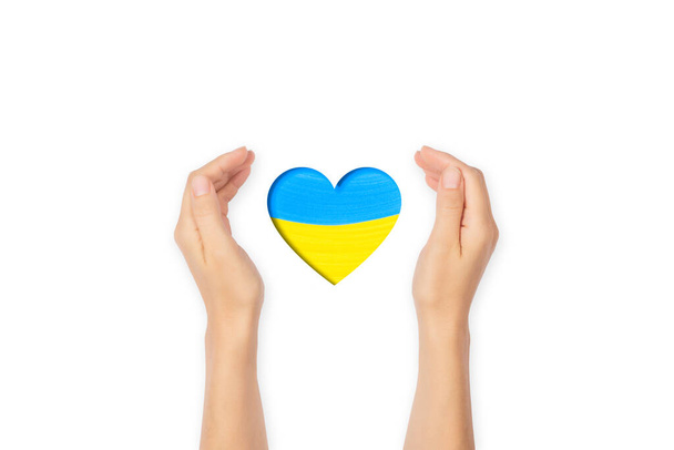 Открытый жест ладони. Открытые ладони с сердцем в цветах украинского флага. Концепция прекращения войны на Украине  - Фото, изображение