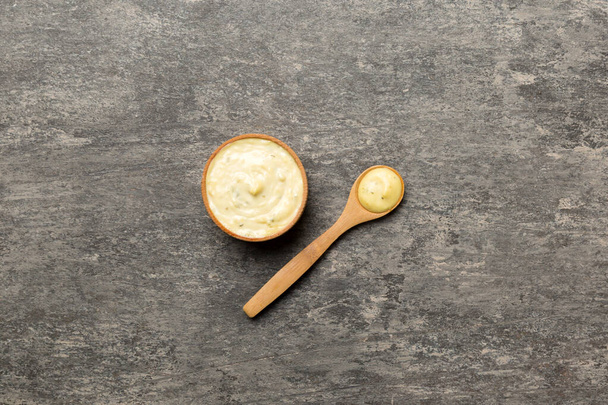 Salsa di formaggio in ciotola di legno con cucchiaio su fondo di cemento. Vista dall'alto con spazio di copia. - Foto, immagini