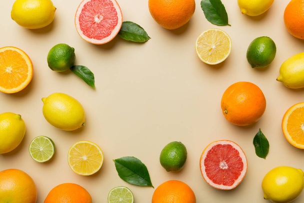 Flat lay of citrus fruits like lime, orange and lemon with lemon tree leaves on light colored background making a frame. Space for text healthy concept. - Fotografie, Obrázek