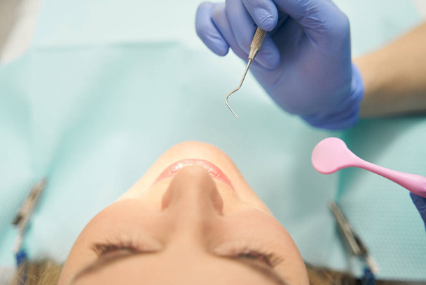 Dentist examining woman teeth with dental tools - Photo, image