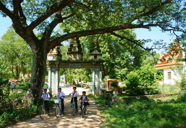 Group Asian kids, riding bike, Khmer village gate - Photo, Image