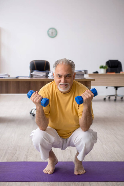 Vecchio impiegato uomo d'affari che fa esercizi sportivi in ufficio - Foto, immagini