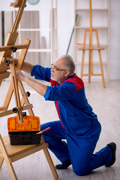 Old male carpenter repairing drawing easel - Photo, Image