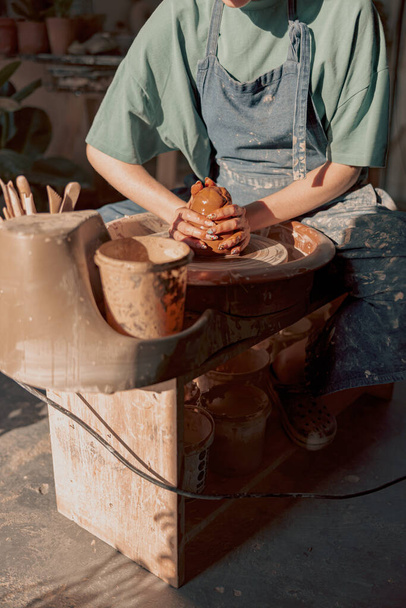 Potter pracuje ručně na hrnčířském kole v dílně - Fotografie, Obrázek