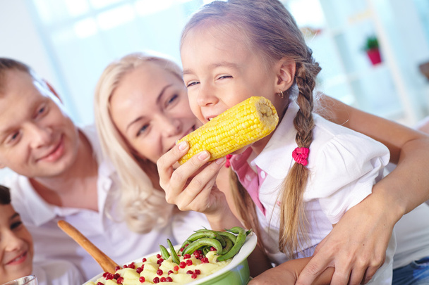 Dziewczynka jedzenie kukurydziany z jej strony matki - Zdjęcie, obraz