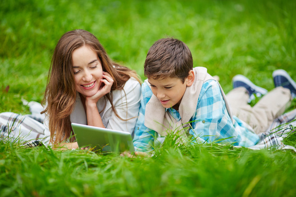 Mujer e hijo usando tableta digital al aire libre
 - Foto, Imagen