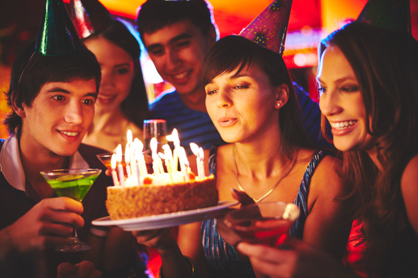 Femme soufflant sur les bougies sur le gâteau d'anniversaire
 - Photo, image