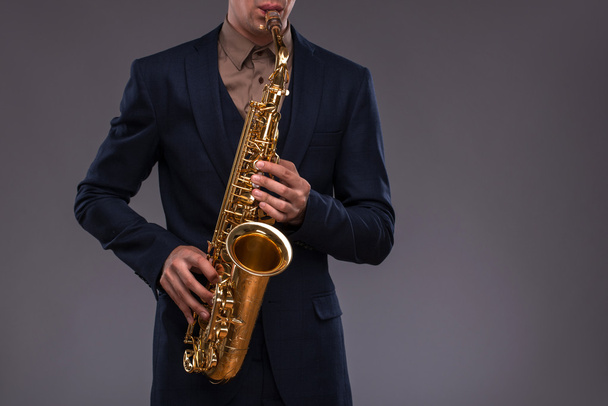 Nahaufnahme einer Trompete in den Händen eines Jazzers im Anzug i - Foto, Bild