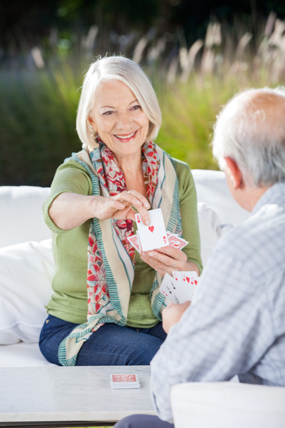 Smiling Senior Woman Playing Cards With Man - Foto, Imagem