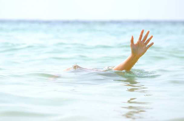 Adamın eli boğuldu, elini kaldırdı ve denizde boğulmak için yardım istedi.. - Fotoğraf, Görsel