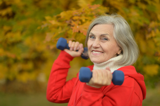 Mature woman with dumbbells - 写真・画像