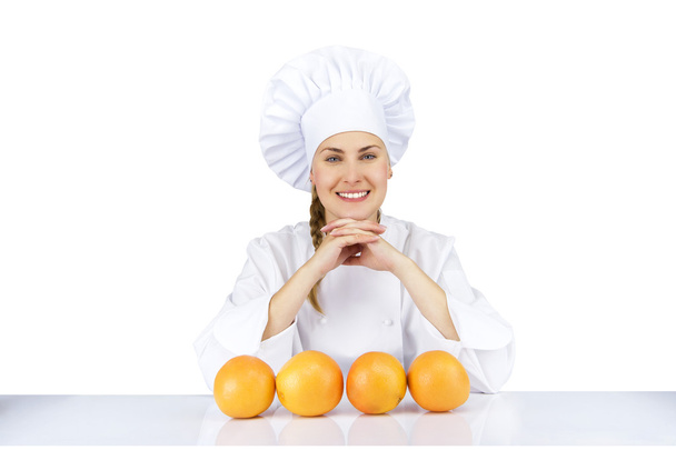 Woman chef in uniform. Isolated on white background with oranges - Foto, Bild