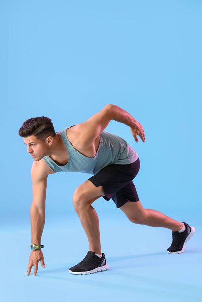 Sporty male runner on color background - Фото, изображение