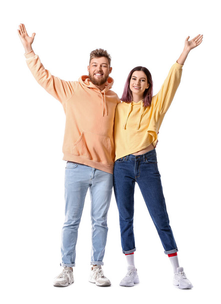 Cool happy young couple in hoodies on white background - Zdjęcie, obraz
