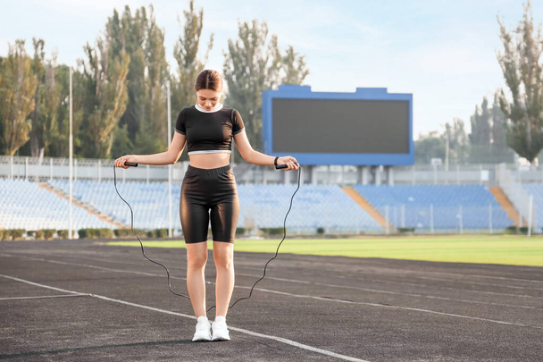 Sporty young woman training with skipping rope in the stadium - Φωτογραφία, εικόνα