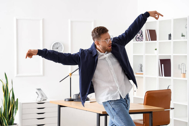 Handsome young businessman dancing in office - Photo, Image