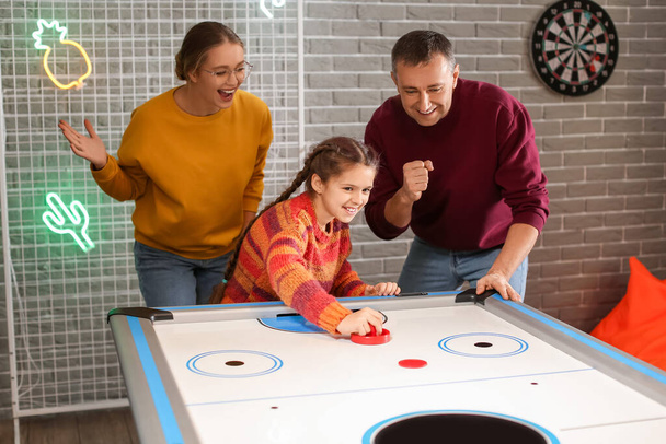 Οικογένεια παίζει χόκεϊ αέρα σε εσωτερικούς χώρους - Φωτογραφία, εικόνα