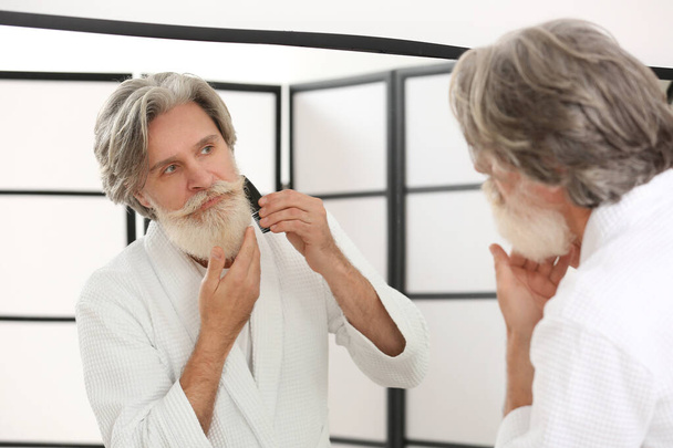 Hombre maduro cuidando su barba y bigote en el baño - Foto, imagen