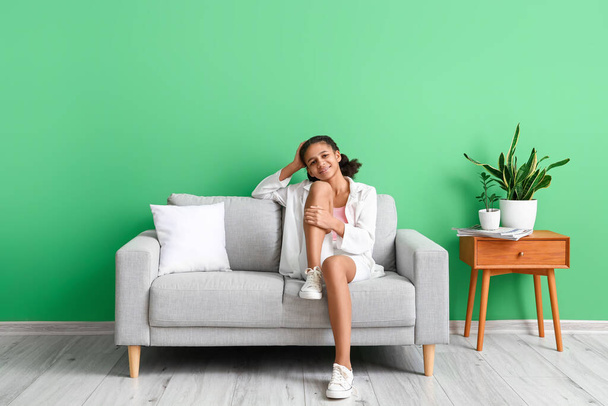 Ragazza afro-americana adolescente rilassante sul divano di casa - Foto, immagini