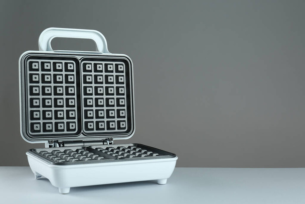 Open electric waffle maker on light grey background. Space for text - Foto, immagini