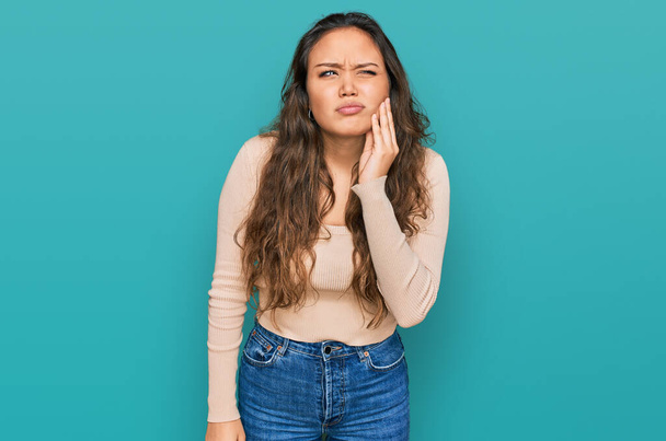 Menina hispânica jovem vestindo roupas casuais tocando a boca com a mão com expressão dolorosa por causa de dor de dente ou doença dentária nos dentes. dentista  - Foto, Imagem