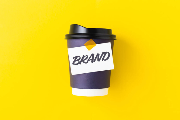 Marka słowo na wynos filiżanka kawy, makieta na żółtym tle, branding, projekt logo tożsamości marki - Zdjęcie, obraz