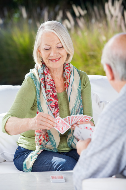 Mujer mayor feliz jugando cartas con el hombre
 - Foto, imagen