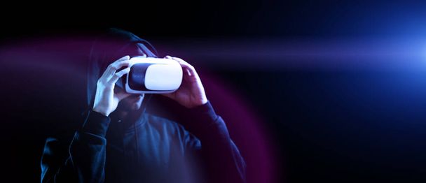 Vr goggles virtual reality. Young man in digital helmet for 3d virtual reality game on dark background. Study and virtual world in 3D simulation - Photo, Image