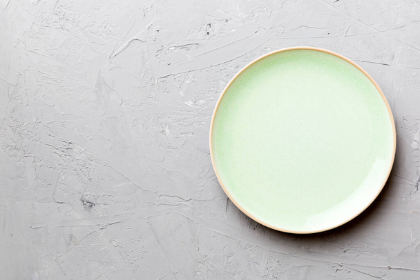 Top view of empty green plate on cement background. Empty space for your design. - Foto, Bild
