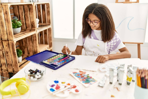 Африканская американка улыбается уверенно рисуя в художественной школе - Фото, изображение