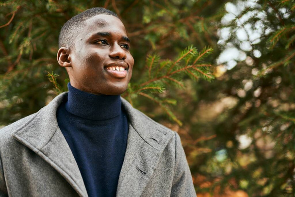 Jovem afro-americano sorrindo feliz de pé no parque. - Foto, Imagem