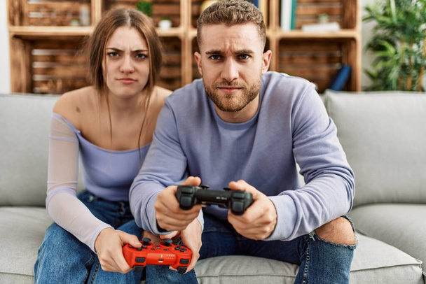 Young caucasian couple concentrated playing video game at home. - Photo, Image