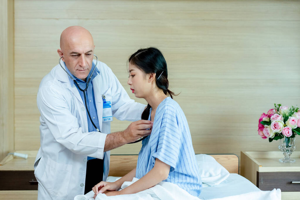 médecin en utilisant stéthoscope vérifier la fréquence cardiaque femme patiente. examen diagnostic pouls check-up à l'hôpital. - Photo, image