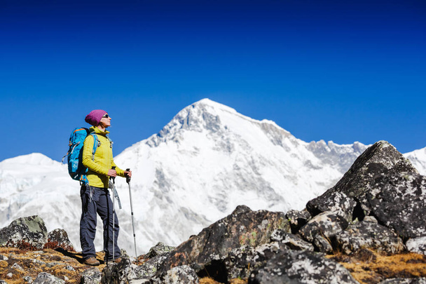 Woman Traveler with Backpack hiking in Mountains with beautiful Himalaya landscape on background. Mountaineering sport lifestyle concept - Φωτογραφία, εικόνα
