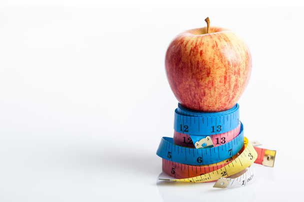 Red apple on four color measuring tapes - Zdjęcie, obraz