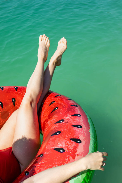 pernas sexy da mulher no anel inflável que flutua no espaço azul da cópia da água do lago - Foto, Imagem