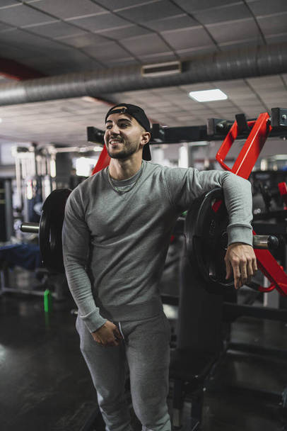 handsome young man in sportswear posing in gym - Fotó, kép