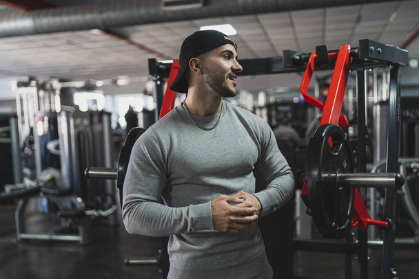 handsome young man in sportswear posing in gym - Photo, image