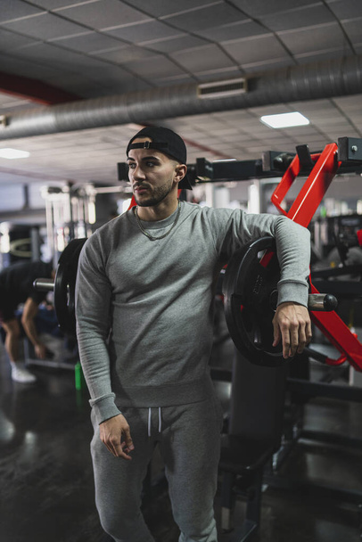 handsome young man in sportswear posing in gym - Foto, Imagen