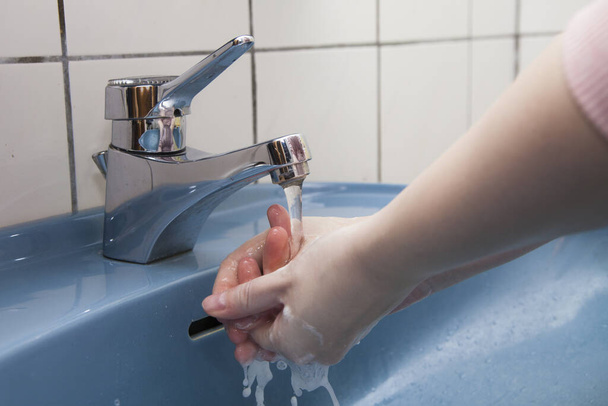 woman washing hands with soap and water  - Foto, afbeelding