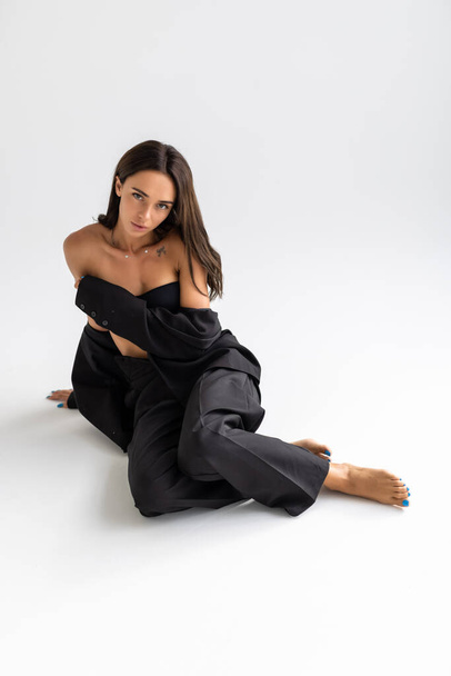 Portrait of a brunette woman in a business suit on the floor - Photo, Image