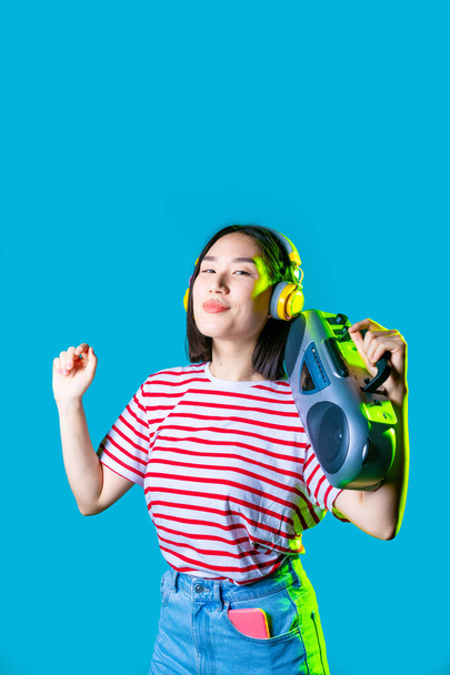 Młoda azjatycka kobieta odizolowany słuchanie muzyki gospodarstwa boombox słuchanie muzyki taniec uśmiech - Zdjęcie, obraz