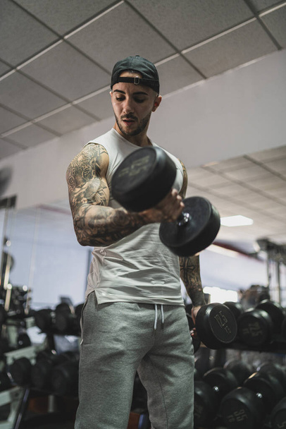handsome young man in sportswear posing in gym - Фото, изображение