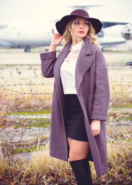 Mulher caminha perto do aeroporto em humor de sonho no início da primavera, vestindo lã casaco elegante oversize - Foto, Imagem