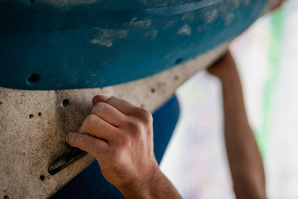 Крупный план мужской руки, размазанной магниевым порошком, хватающейся за стену в спортзале. - Фото, изображение