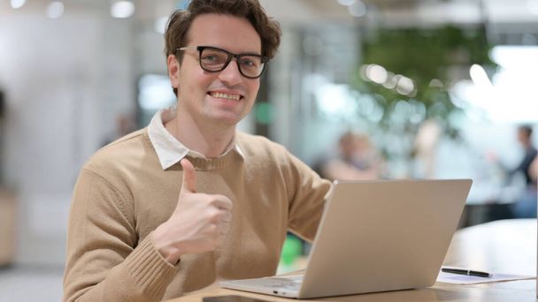 Young Man with Laptop showing Thumbs Up Sign  - Foto, Imagen